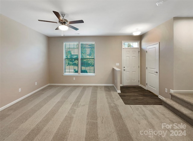 carpeted foyer with a healthy amount of sunlight and ceiling fan