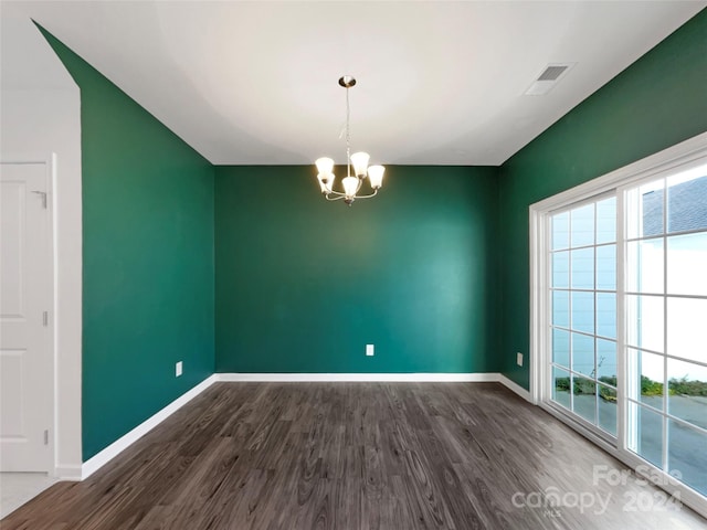 unfurnished room featuring dark hardwood / wood-style floors and an inviting chandelier