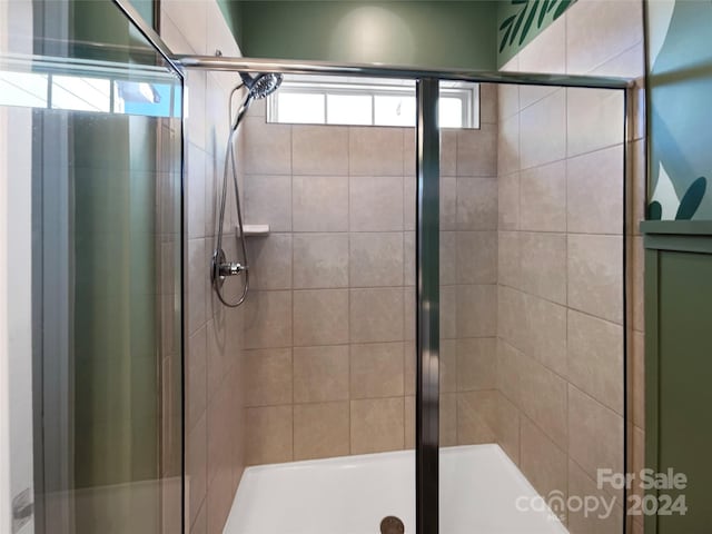 bathroom featuring a shower with shower door