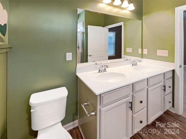 bathroom with toilet, hardwood / wood-style flooring, and vanity