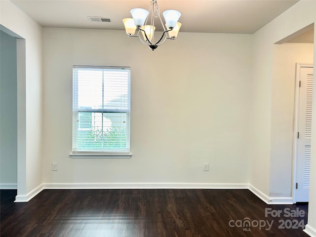 unfurnished dining area with dark hardwood / wood-style floors and a chandelier