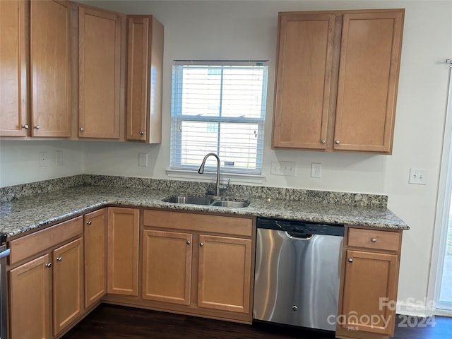 kitchen featuring dishwasher, dark hardwood / wood-style floors, stone counters, and sink