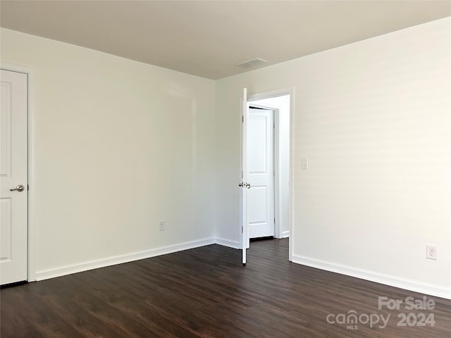 empty room with dark wood-type flooring