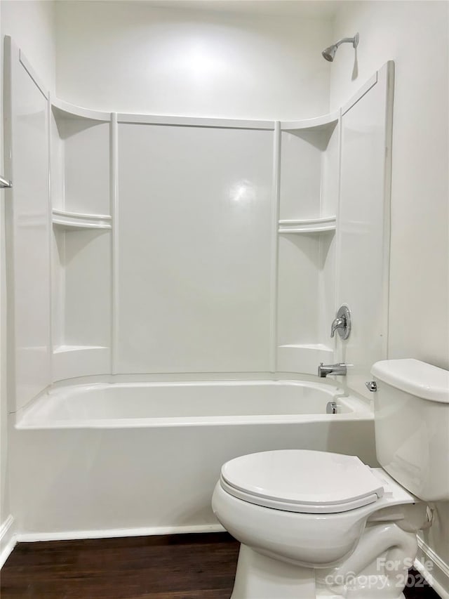 bathroom with hardwood / wood-style floors, shower / bath combination, and toilet