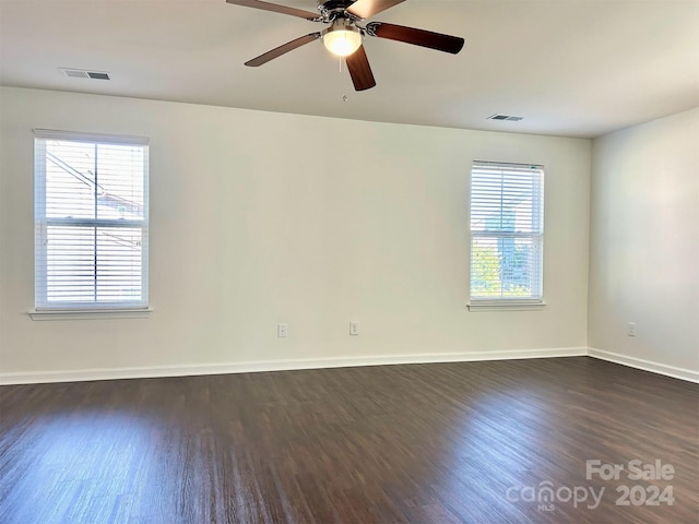 spare room featuring plenty of natural light, ceiling fan, and dark hardwood / wood-style flooring