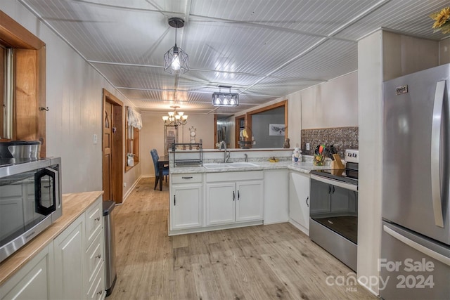 kitchen with sink, light wood-type flooring, hanging light fixtures, stainless steel appliances, and white cabinets