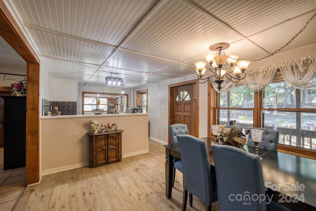 dining room with a wealth of natural light, a notable chandelier, and light wood-type flooring