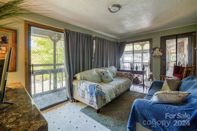 living room with crown molding, a textured ceiling, and a wealth of natural light