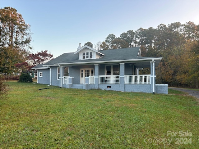 view of front of house with covered porch and a front lawn