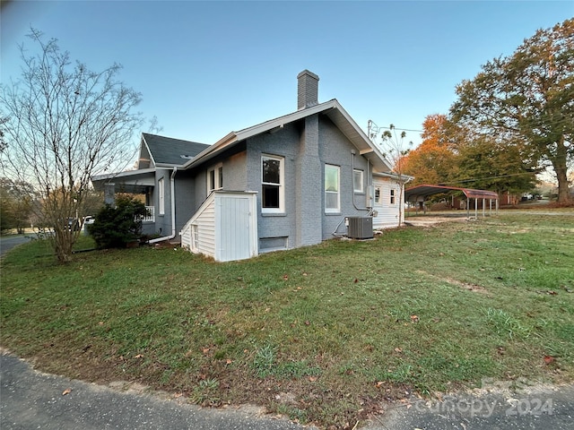124 Elam St, Lawndale, NC 28090 - view of side of home with a lawn, cooling unit, a chimney, and a detached carport