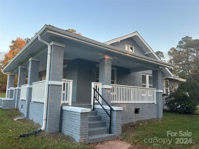 view of side of property featuring covered porch