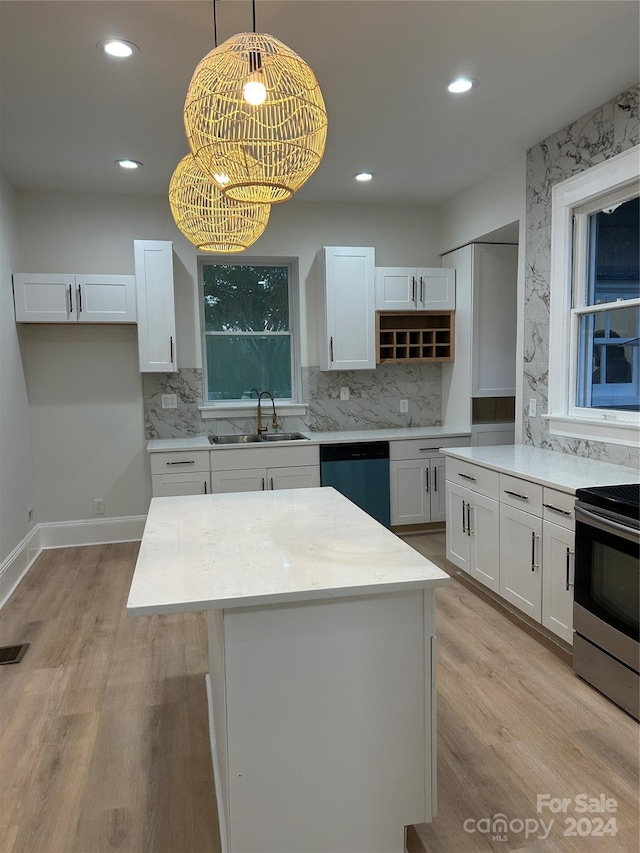 kitchen featuring sink, a kitchen island, hanging light fixtures, white cabinetry, and stainless steel appliances