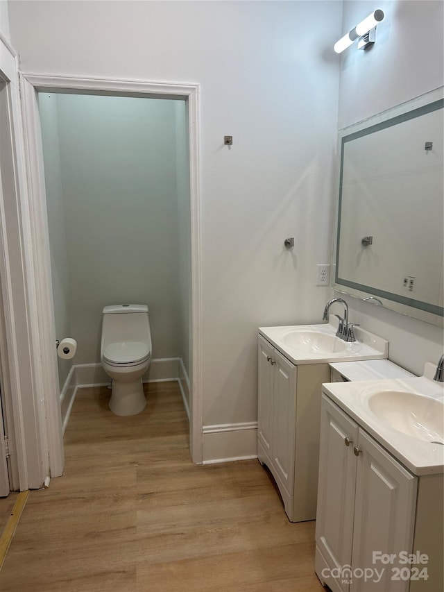 bathroom featuring vanity, toilet, and hardwood / wood-style floors