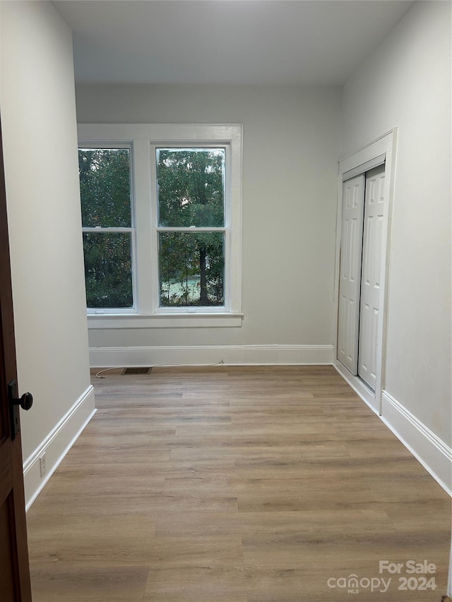 unfurnished bedroom featuring light hardwood / wood-style floors and a closet