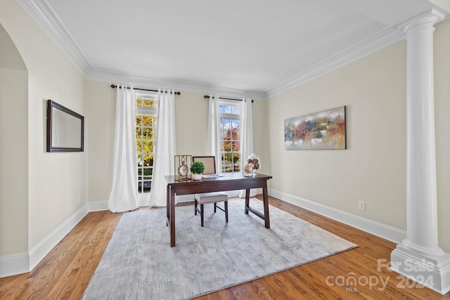 office with light hardwood / wood-style floors, crown molding, and decorative columns