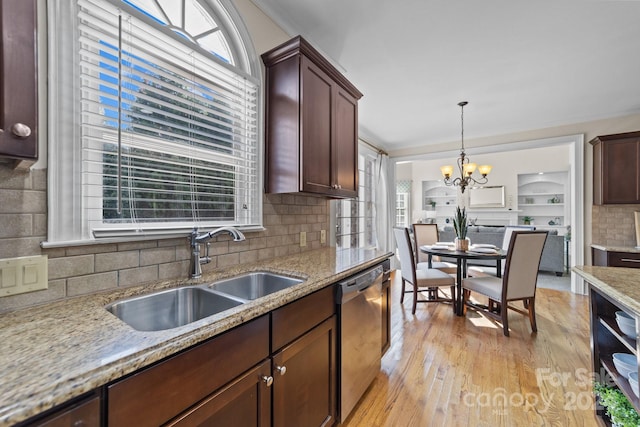 kitchen with plenty of natural light, light hardwood / wood-style flooring, sink, and stainless steel dishwasher