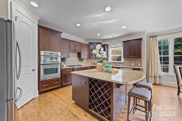 kitchen featuring light hardwood / wood-style flooring, a healthy amount of sunlight, stainless steel appliances, and a kitchen island