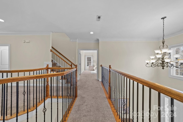 hallway with crown molding, light carpet, and a chandelier