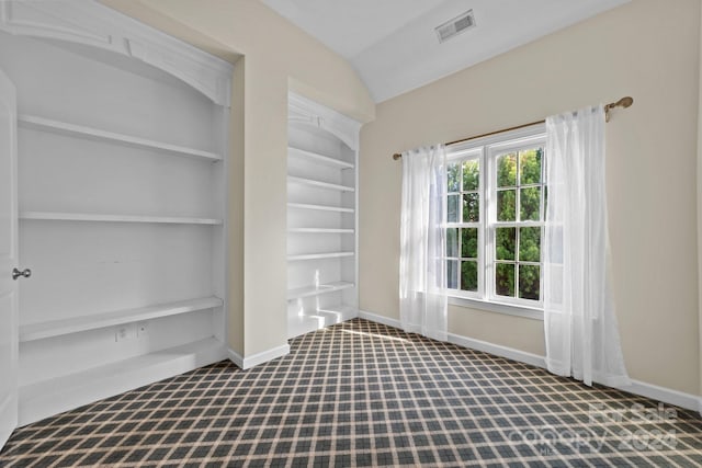 empty room with lofted ceiling and built in shelves