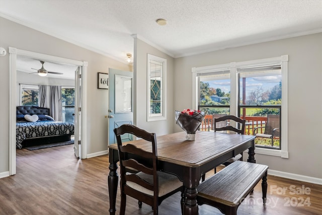 dining room with wood-type flooring, a textured ceiling, ceiling fan, lofted ceiling, and crown molding