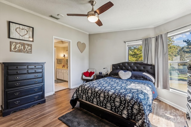 bedroom with ceiling fan, a textured ceiling, wood-type flooring, ornamental molding, and ensuite bathroom