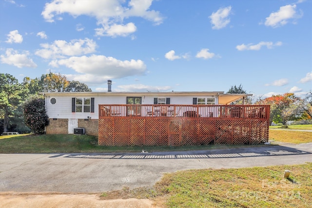 view of front facade featuring cooling unit, a front yard, and a deck