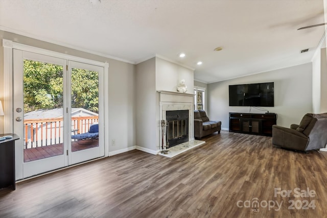 living room with a high end fireplace, hardwood / wood-style floors, and crown molding