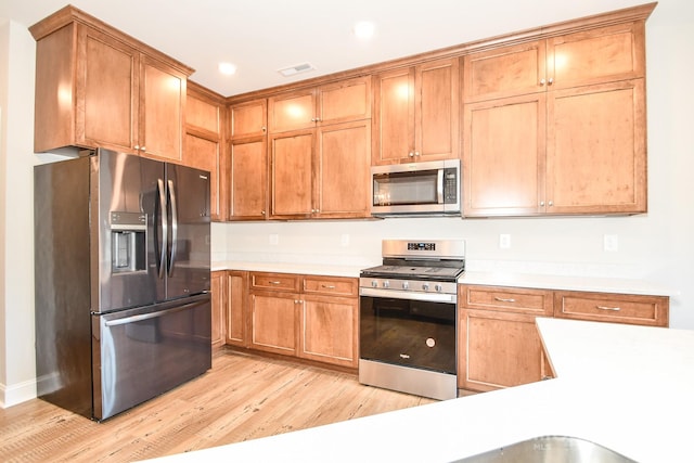 kitchen with appliances with stainless steel finishes and light wood-type flooring