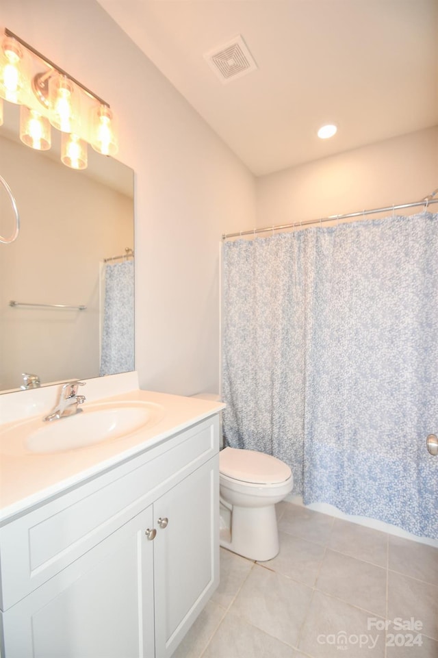 bathroom with vanity, toilet, curtained shower, and tile patterned flooring