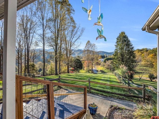 wooden deck featuring a mountain view and a lawn