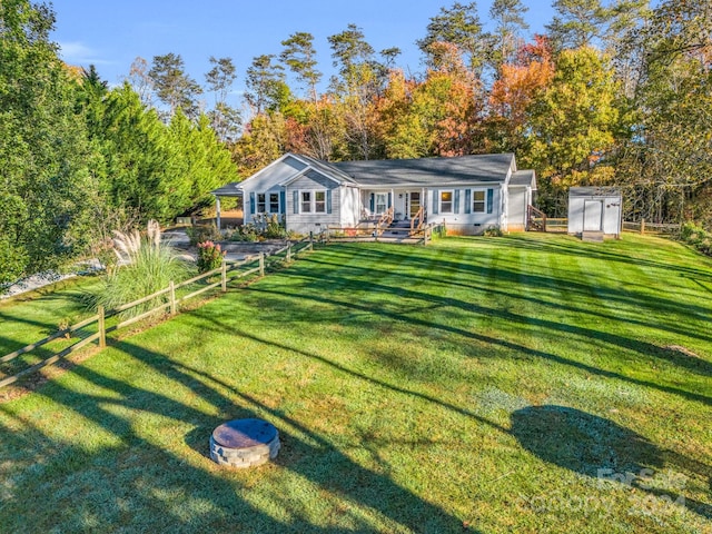 rear view of property featuring a storage unit and a lawn