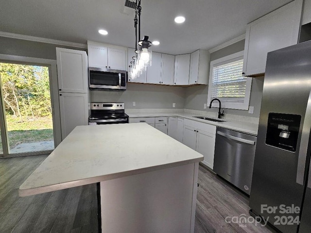 kitchen featuring crown molding, a center island, stainless steel appliances, and white cabinets