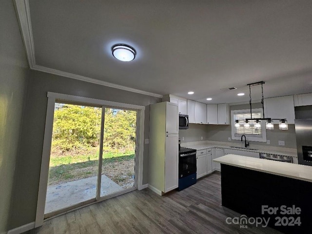 kitchen with sink, hanging light fixtures, white cabinetry, stainless steel appliances, and dark wood-type flooring