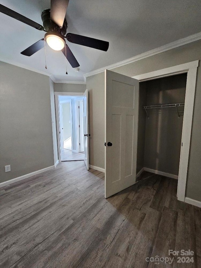 unfurnished bedroom featuring dark hardwood / wood-style flooring, ornamental molding, a closet, and ceiling fan