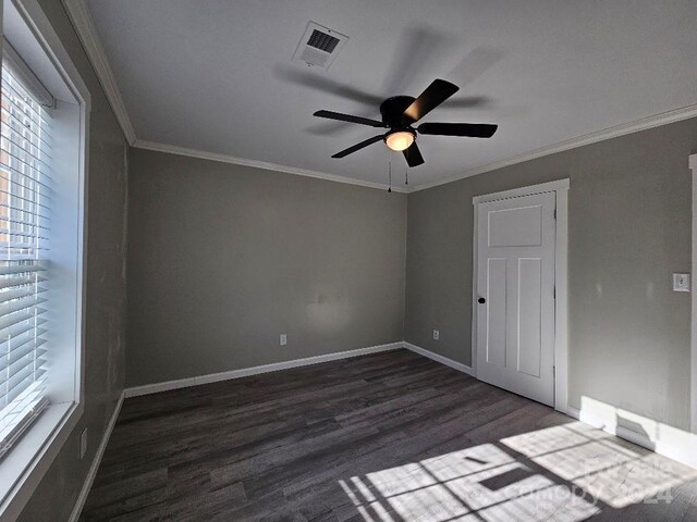 unfurnished room with crown molding, ceiling fan, and dark hardwood / wood-style flooring