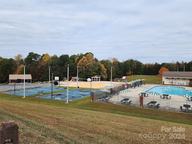 view of pool featuring a playground and a lawn