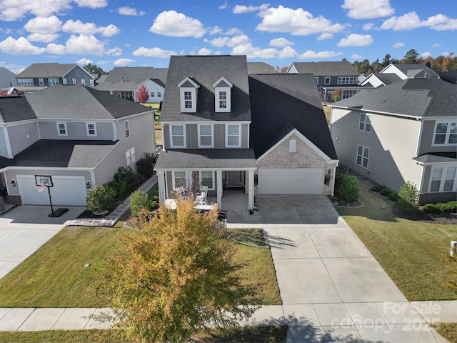 view of front of home featuring a garage, concrete driveway, a residential view, roof with shingles, and a front yard