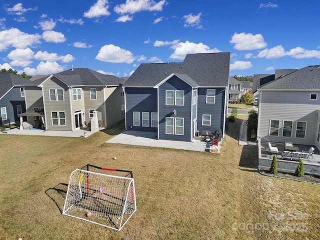 rear view of house with a residential view, a patio, and a lawn