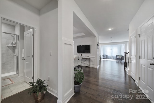 corridor with baseboards and wood finished floors