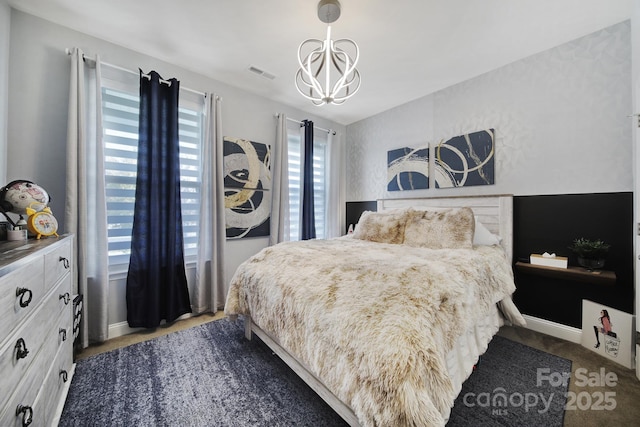 bedroom with baseboards, carpet, visible vents, and a notable chandelier