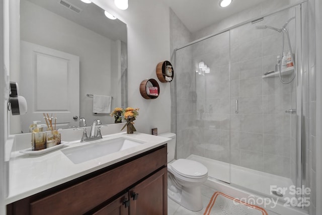 bathroom with visible vents, a shower stall, toilet, and vanity