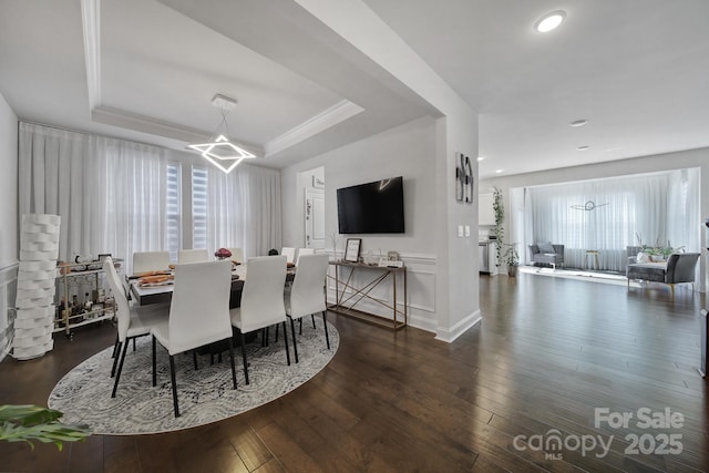 dining area featuring a notable chandelier, crown molding, recessed lighting, a raised ceiling, and hardwood / wood-style floors