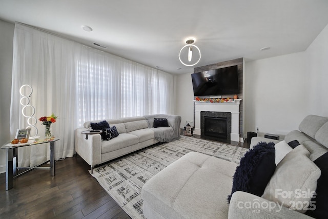 living area featuring a fireplace, visible vents, and hardwood / wood-style floors