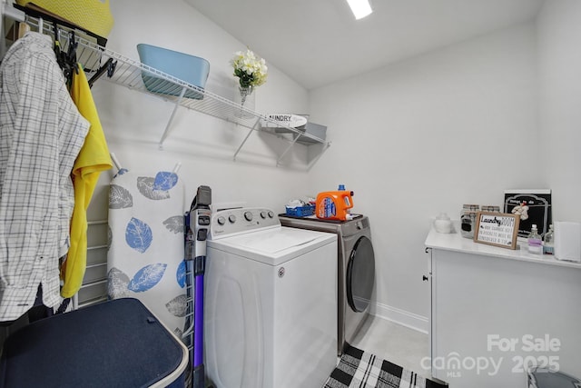 laundry area with laundry area, baseboards, and washer and clothes dryer