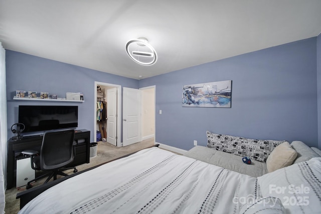 bedroom featuring a closet, carpet flooring, a spacious closet, and baseboards