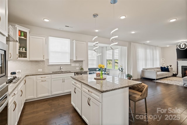 535 Red Wolf Ln, Lake Wylie, SC 29710 - kitchen with dark wood finished floors, white cabinets, glass insert cabinets, a kitchen island, and tasteful backsplash