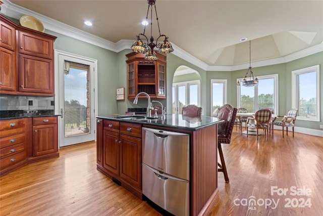 kitchen featuring tasteful backsplash, a kitchen island with sink, light wood-type flooring, dishwasher, and sink