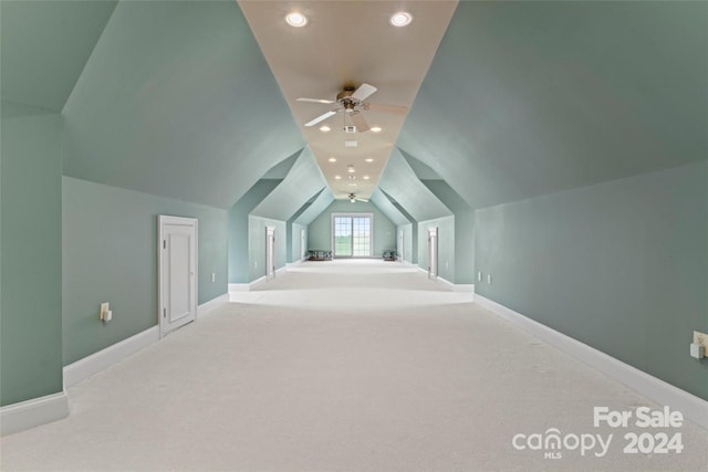 additional living space featuring vaulted ceiling, light colored carpet, and ceiling fan