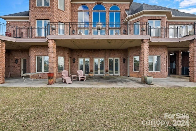 back of property featuring a balcony, a yard, and a patio area