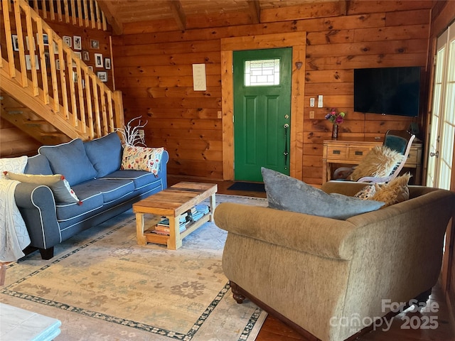 living room with lofted ceiling and wood walls